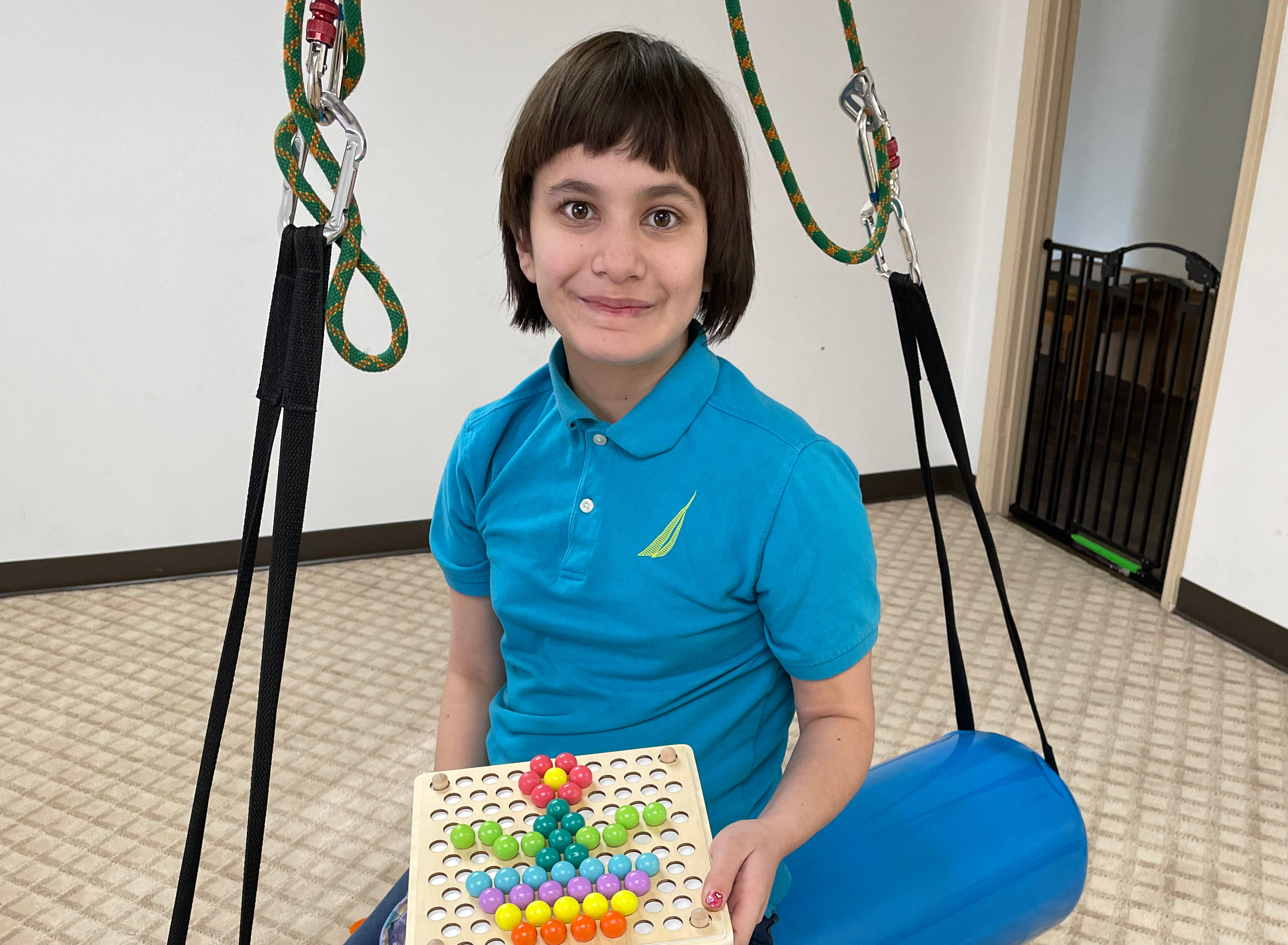 patient sitting on treatment swing holding a flower puzzle